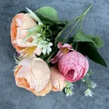 Ramo de rosas artificiales con capullos naranjas y rosas sobre tela azulada - Rosa