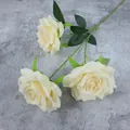 Three-head artificial cream roses with realistic green leaves on gray cement background - Champagne