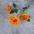 Artificial orange roses with three heads and green leaves on a textured grey background - Orange