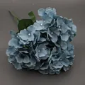 Stelo di ortensia artificiale blu polvere con foglie verdi su uno sfondo scuro opaco - Blu Foschia Con Foglie