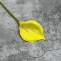 Einzelne künstliche PU-Calla-Lilie in Gelb auf grauem Hintergrund mit Textur - Gelb