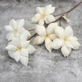 Single spray of 5 cream artificial magnolias with green leaves on grey stone background - Champagne