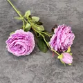 Kunstmatige lila rozen met drie koppen, twee bloemen en een knop op een grijze achtergrond - Paars