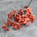 Close-up of artificial orange autumn leaves with detailed veins on a long decorative stem - Medium / Orange Red