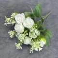 Künstlicher weißer Rosenstrauß mit Seidenblüten und grünen Blättern auf grauem Stoff - Weiß