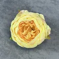Künstlicher Pfingstrosenkopf mit orange-gelbem Farbverlauf auf grauem Samt - Gelb