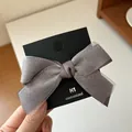 Elegant double-layered mesh bow hair clip in grey color on a display card - Gray