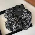 Detail of satin leopard print hair scrunchie with nyu.nyu tag and made in Korea label - Grey and Black Leopard Print