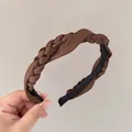 Dettaglio macro del cerchietto in raso marrone con trama intrecciata e fodera antiscivolo - Marrone scuro