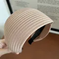 Makroaufnahme von hellbraunem, geripptem, breitem Strickstirnband mit weicher Textur und Futter - Khaki