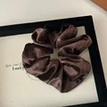 Dettaglio di elastico per capelli in velluto marrone con glitter e morbide pieghe - Marrone scuro