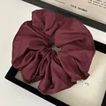 Detail of burgundy ruffled scrunchie with textured fabric and fine stitching - Burgundy