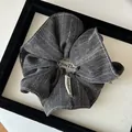 Dunkelgraues gestreiftes Haargummi mit Handmade-Etikett in schwarzem Samt-Display - Schwarz