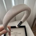 Dettaglio cerchietto in raso beige con etichetta fatta a mano e trama liscia del tessuto - Albicocca Beige