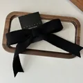 Eleganter schwarzer Strick-Haarclip mit strukturierter Schleife auf Display-Karte - Schwarz