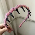 Nahaufnahme des rosa gestrickten Haarreifens mit flauschiger Wolle und rutschfesten Zähnen - Rosaviolett
