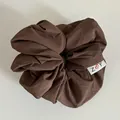 Détail du chouchou marron café avec étiquette tissée Z cœur Y et texture plissée - Café Foncé