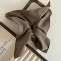 Detalle de scrunchie de tela marrón con etiqueta HAND MADE en bandeja de madera - Lazo De Bufanda Cuadrada Patchwork