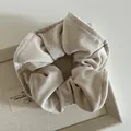 Macro shot of French style champagne beige velvet hair scrunchie with soft pearl luster - Beige