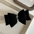 Dettaglio di fermaglio a doppio fiocco in velluto nero con perline argentate - Nero