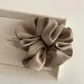 Macro detail of a large mocha satin scrunchie showing smooth silk texture and soft folds - Khaki