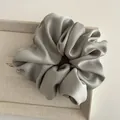 Macro shot of large matte satin scrunchie in misty blue with rich fabric texture and folds - Green