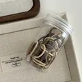 Macro view of woven elastic hair ties in earth tones stored in a clear cylinder jar - Milk Coffee Series