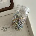 Macro view of colorful elastic hair ties set neatly stored in a clear cylindrical bottle - Morandi Colors
