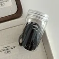 Jar of high-elastic black hair ties on minimalist jewelry tray for hair styling - All Black