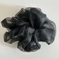 Macro shot of large black organza scrunchie with layered pleats and translucent texture - Black