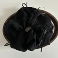 Detail of black pleated fabric scrunchie with ribbon bows on a wooden tray - Black