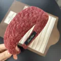 Dettaglio ravvicinato del cerchietto in lana rosso scuro con trama spessa ed etichetta - Stile F Rosso 4cm