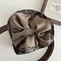 Close-up of leopard print and coffee satin fabric patchwork on large scrunchie - Brown