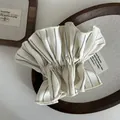 Detalle de coletero a rayas crema con motivos de puntos negros en bandeja de madera - Blanco Roto