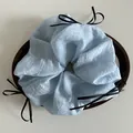 Detailed view of light blue oversized scrunchie with three delicate black ribbon bows - Blue