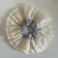 Close-up of oversized layered ruffle scrunchie with gold logo tag and soft mesh texture - Milky Blue