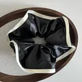 Nahaufnahme eines Vintage Satin-Haargummis in Schwarz mit elfenbeinfarbener Kante - Schwarz