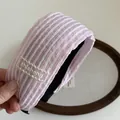 Detailed macro view of pink and white striped fabric headband with lace embroidery detail - Pink