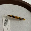 Détail d'une barrette en acétate écaille de tortue avec gravure dorée élégante - Écaille de Tortue Foncée