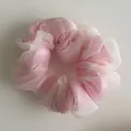Detailed texture of pink and cream layered organza fabric on an elegant large scrunchie - Pink