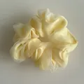 Detailed close-up of light yellow double-layered mesh organza scrunchie with soft pleats - Yellow