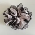 Detailed view of pink pleated fabric hair scrunchie with elegant black mesh lace trim - Pink