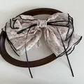 Floral French bow hair clip with black piping and ribbons on a rustic wooden tray - Lotus Pink