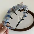 Détail d'un serre-tête en mousseline fleurie bleue avec dents et étiquette faite main - Bleu