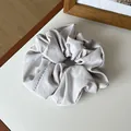 Elegant mauve grey matte scrunchie hair tie on white surface with a wooden frame - Light Gray