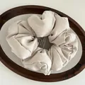 Beige puffy cloud scrunchie in soft matte fabric displayed on a vintage wooden tray - Beige