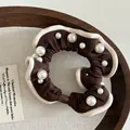Detailed view of vintage pearl scrunchie in deep brown with cream trim and elegant pearls - Brown
