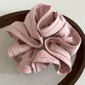 Detail of a large ruffled pink hair scrunchie with knit texture and French retro design - Pink