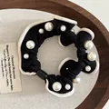 Coletero negro elegante con detalles de perlas blancas y ribete crema en contraste - Negro