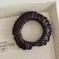 Solid deep brown ruffled satin scrunchie with silky finish on a beige textile tray - Dark Coffee